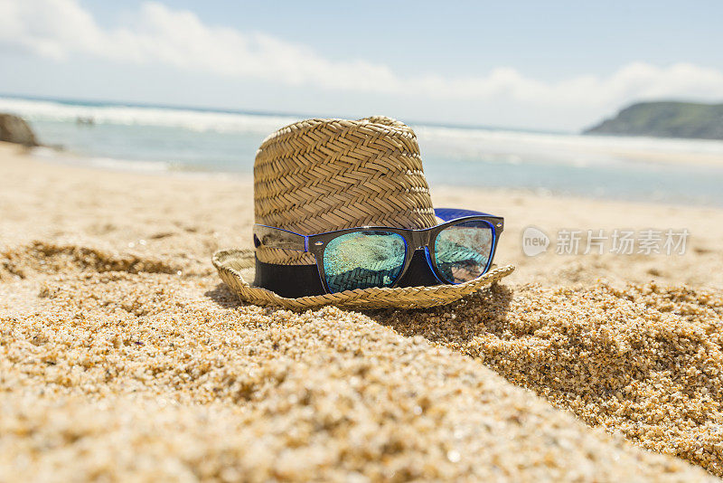 帽子和太阳镜在沙滩上，Pedn Vounder海滩，康沃尔。